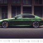 Juni Kalender, BMW M5 Competition (F90). Dunkelgrünes Auto vor moderner Gebäudefassade.