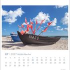 Juli 2027, Rügen. Zwei Boote am Strand mit roten Fahnen, blauer Himmel und Wolken. Logo EILAND.