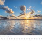 JULI 2027 | KÜSTENLAND Meer erleben. Kalenderblatt mit Sonnenuntergang über einem Strand und Pfahlbauten am Horizont.