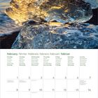 Kalenderseite für Februar 2027. Oben ein Bild: Eiskristall am Meer bei Sonnenaufgang. Wochentage in mehreren Sprachen.