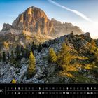 Text: "Dolomiten 07" und "Tofana di Rozes". Ein beeindruckender Berg bei Sonnenuntergang mit grünem Vordergrund.