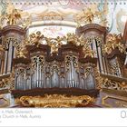 Kalenderseite: Juli. Text: "Stiftskirche in Melk, Österreich." Barocke Orgel mit goldenem Dekor. Engelsfiguren und Deckenfresko.