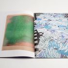 Links abstraktes Kunstwerk in Grün und Braun. Rechts blau-weiße Muster auf kariertem Boden.