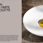 "Pistazien-Wakame-Tarte mit Mimolette. Karamellisierte Aprikose." Links Text, rechts ein Teller mit feiner Präsentation.