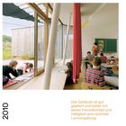 Texte: "Volksschule Bad Blumau", "Das Gebäude ist gut gealtert und bietet mit seiner Freundlichkeit und Helligkeit eine optimale Lernumgebung." Jahr: "2010". Szene: Klassenzimmer mit großen Fenstern, Kinder arbeiten an Tischen.