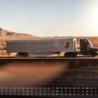 Kalenderdaten im Vordergrund, ein UPS-Lastwagen fährt durch eine Wüstenlandschaft bei Sonnenlicht.