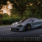 Kalender mit Monatsübersicht. Ein grauer Sportwagen fährt schnell auf einer Straße, Bäume im Hintergrund verschwommen.