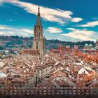 Kalender für den Monat August mit der Stadt Bern. Im Hintergrund ist der Turm eines großen, alten Gebäudes zu sehen.