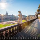 Kalender unter einer sonnigen Szene des Dresdner Zwingers mit Statuen und imposanter Architektur.