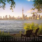 Kalenderdaten unten. "Toronto Skyline" Text. Blick auf Skyline bei Sonnenuntergang, Stühle am Wasser, Bäume rahmen Szene ein.