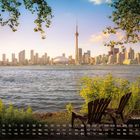 Kalender mit Toronto Skyline, Juli 7. Zwei Stühle am Wasser mit Blick auf die Stadt am Abend.