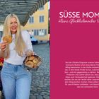 "SÜSSE MOMENTE Kleine Glücklichmacher für jeden Tag". Eine langhaarige Frau hält eine Zimtschnecke auf einem Markt.