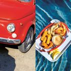 Links ein rotes Auto, rechts ein Tablett mit Pommes, Garnelen und Soße, darunter blaue Wasserreflexionen.