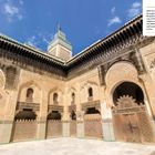 Text beschreibt Minarett und Medersa Bouanania in Fes, zugänglich für Nicht-Muslime. Architektur mit verzierten Bögen.