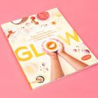„GLOW“, gelb hervorgehoben; Rezeptbuch mit Händen, Schale, Früchten. Heller Hintergrund, rosa Elemente.