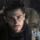 Es gibt keinen erkennbaren Text. Ein Mann mit ernstem Gesichtsausdruck trägt eine Ausrüstung im gedämpften Licht.