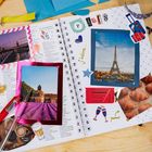 Texte: "Paris", "J'adore", "Eintrittskarte", "Yummi!".  
Gescrapbookte Seite mit Paris-Fotos, Tickets und Sticker.