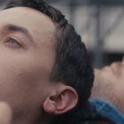 Zwei Personen liegen nebeneinander, Augen halb geschlossen, wirken nachdenklich oder entspannt.