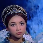 Keine Texte zu sehen. Eine junge Frau trägt eine verzierte Tiara. Farben sind überwiegend blau und silbern.