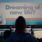 „Dreaming of a new life?“ und „Somnium“ auf einer Werbetafel mit einer lächelnden Person in Arztkleidung.