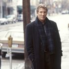 Zwei Männer stehen auf einer winterlichen Straße und unterhalten sich ernsthaft. Im Hintergrund sind Autos und ein paar Menschen.