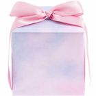 Ein zart pastellfarbenes Geschenk mit einem rosa Band, das zu einer Schleife gebunden ist.