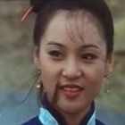 Es gibt keinen sichtbaren Text. Frau mit schwarzen Haaren, in blauer Kleidung und mit roten Lippen lächelnd.