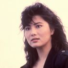 Ich weiß nicht, wer die Person ist. Sie hat dunkle, lockige Haare und trägt eine dunkle Jacke vor einem hellen Hintergrund.