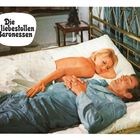 "Die liebestollen Baronessen." Eine blonde Frau liegt mit einem Mann im Bett, sie scheint entspannt zu sein.