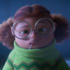 Eine animierte Figur mit runder Brille und lockigem Haar trägt einen grünen Pullover mit buntem Zickzack-Muster.