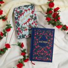 „New Moon“ und „Stephenie Meyer“ auf zwei Büchern mit Blumenmustern, umgeben von roten Rosen auf einer Decke.