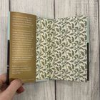 Buchtext beschreibt vierzehn Hunde von Elizabeth von Arnim. Farbiges Muster im Hintergrund zeigt grüne Blätter und Ranken.