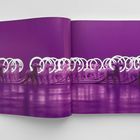 Keine erkennbaren Texte. In einem Buch: mehrere lilafarbene Skulpturen mit Kabeln und weißen Ringen auf lila Hintergrund.