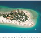„Ölüdeniz“, ein Inselstrand mit Liegestühlen, türkisfarbenem Wasser und üppiger Vegetation.