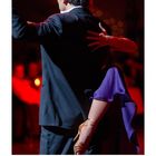 Kalenderseite mit Monat August. Ein Paar tanzt elegant, das Bein der Frau eingehakt. Hintergrund rot beleuchtet.