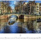 "Altstadt" steht unten. Eine sonnige Kanalszene mit Brücke, Boot und historischen Häusern. Menschen spazieren entlang des Wassers.