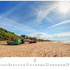 Sonne und Strand in Miedzyzdroje. Sandstrand mit Booten, grüner Wald, Gebäude und strahlende Sonne am Himmel.