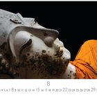 Augustkalender, Zahlen 1-31, Buddha-Statue in Seitenansicht, Gesicht mit orangefarbenem Gewand, schwarzer Hintergrund.