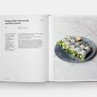 "Daikon Rolls with Avocado and Micro Greens" und Rezepttext auf der linken Seite, Teller mit gefüllten Rollen auf der rechten Seite.