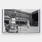 Ein Buch zeigt ein Schwarz-Weiß-Foto mit einem Tennisspieler und einem Schiedsrichterstuhl auf einem Spielfeld.