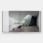 Keine sichtbaren Texte. Ein modernes Interieur mit minimalistischen Möbeln, großen Fenstern, Treppen und Pflanzen.