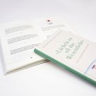 Ein aufgeklapptes Buch zeigt Zitate, daneben liegt ein Buch mit dem Titel »Lächeln ist oft das Wesentliche«.