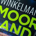 "Winkelmann Moorland Thriller" in großen Buchstaben. Dunkle, stürmische Landschaft im Hintergrund.