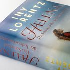 Text: "Iny Lorentz, Helena, Das Schicksal der Todesschwestern, Roman". 
Cover zeigt eine Frau am Meer, in historischer Kleidung.