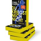 Buchstapel mit Titel „Du kriegst mich nicht“ von Chris Carter, gelber Rand, silberne Silhouette einer Frau.