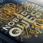 Auf einem Buchcover steht in großen Buchstaben "NOBODY'S QUEEN". Eine dekorative goldene Schlüssel-Illustration.