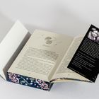 Eine Buchseite mit dem Titel "Damien" und eine schwarze Karte mit Text über Katherine Quinn, eingeschoben in das Buch.