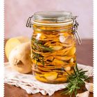 Getrockneter Butternusskürbis in Öl (Rezept S. 60). Ein Glas mit Kürbisscheiben, Knoblauch und Rosmarin in Öl.
