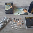„BERSERK PUZZLE“ auf einer Schachtel, Manga-Band „BERSERK 43“, Puzzlestücke und Illustration.