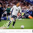 Vorjahresabbildung. Fußballspieler in Aktion, trägt Trikot mit der Nummer 19. Kalenderseite mit dem Monat August unten.